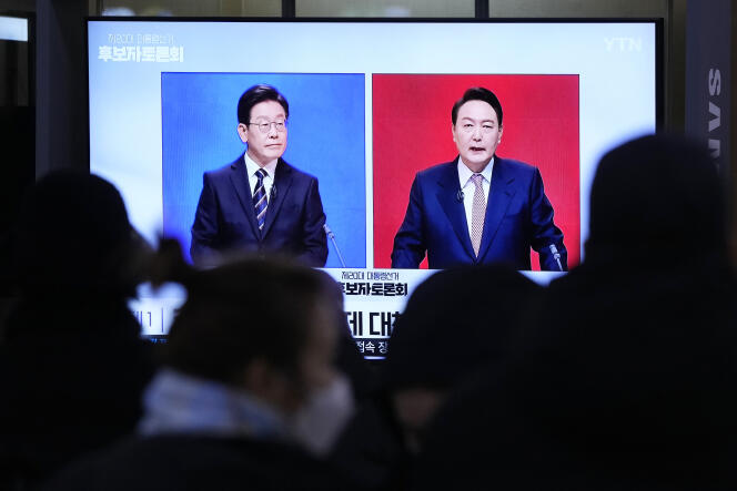 Sur l’écran, le candidat démocrate Lee Jae-myung (à gauche) et le candidat conservateur Yoon Seok-youl (à droite), le 21 février 2022, à Séoul.