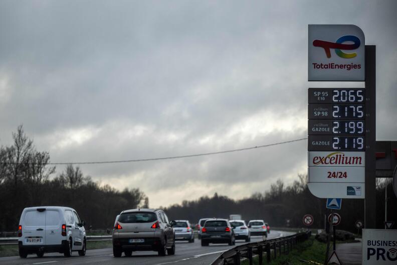 A picture taken on March 8, 2022 in Temple-de-Bretagne shows cars driving past a board indicating the fuel prices at a gas station where refueling has become significantly more expensive as a result of the war in Ukraine. The price of diesel soared by more than 14 cents on average last week in France, in the wake of soaring oil prices since the Russian invasion of Ukraine, according to official figures released on March 7, 2022. (Photo by Loic VENANCE / AFP)