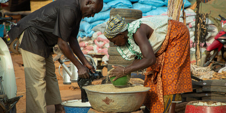 Une vendeuse de Mil en détail qui sert son client dans un sachet.   Copyright : Amadou CISSE