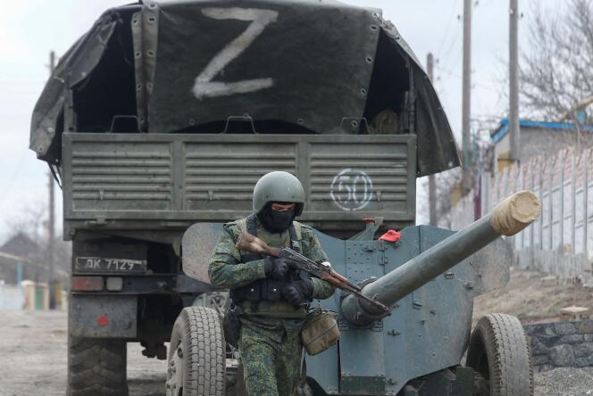 Un soldat russe marche devant un camion marqué de la lettre « Z », dans le village de Bouhas, en Ukraine, le 1er mars 2022.