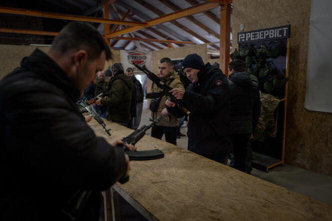 Des civils s’entrainement au maniement des armes encadrés par des militaires dans un entrepot caché à Lviv, en Ukraine, le 8 mars 2022.
