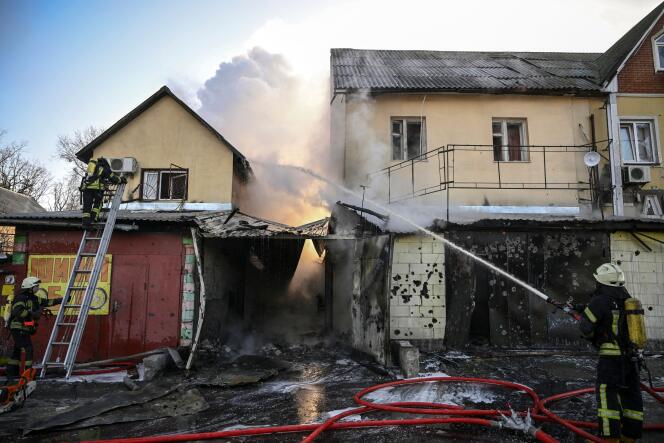 Bomberos intervienen para apagar el fuego en una casa, en Kiev, tras atentados, el 12 de marzo de 2022.