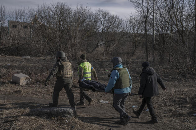 Soldados y voluntarios ucranianos ayudan a evacuar a quienes han tenido dificultades para salir de la ciudad.  Irpin, Ucrania, 11 de marzo de 2022.