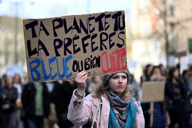 Une manifestante tient une pancarte sur laquelle est inscrit « Ta planète tu la préfères bleue ou bien cuite », lors d’une marche pour le climat baptisée «  Look up », le 12 mars, à Rennes.