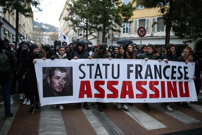 Um banner com uma foto de Yvan Colonna onde está escrito “Estado francês, assassino”, durante uma manifestação em Bastia, 13 de março de 2022.