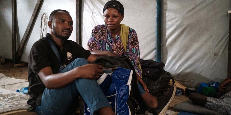 Married couple Denise (r) and Michel (l) show the only belongings they managed to take with them after fleeing DRC, in Bubukwanga transit centre, in Uganda on February 11, 2022.