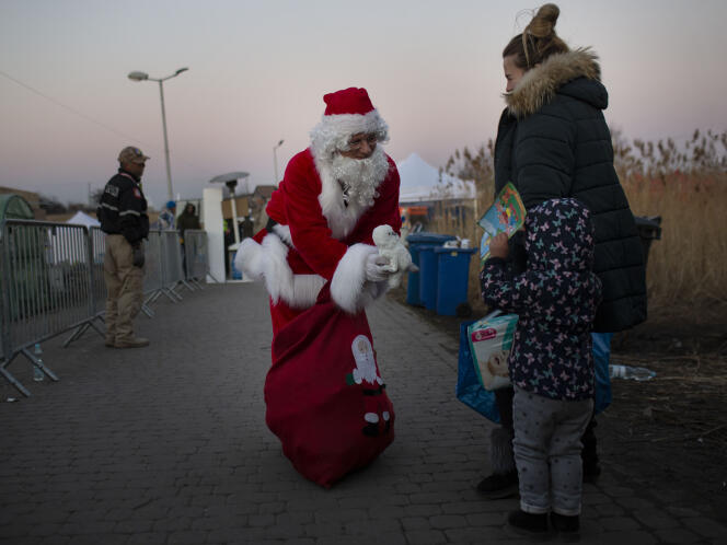 Un Père Noël polonais distribue des jouets aux enfants ukrainiens, au camp de Medyka, le poste-frontière entre la Pologne et l’Ukraine, le 18 mars 2022.