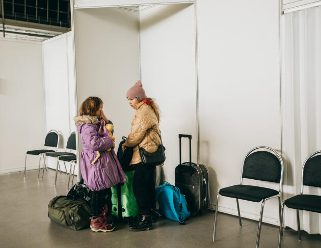 Polina et Lada, originaires de Kharkiv, en Ukraine, attendent que leurs mères s'enregistrent au bureau de recherche d'emplois du centre d’accueil des réfugiés ukrainiens de Brno, en République Tchèque, le 19 mars 2022.