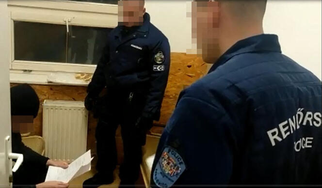 Policía húngara con un hombre identificado como Loïk Le Priol (izquierda), en Nyiregyhaza (Hungría), 23 de marzo de 2022.
