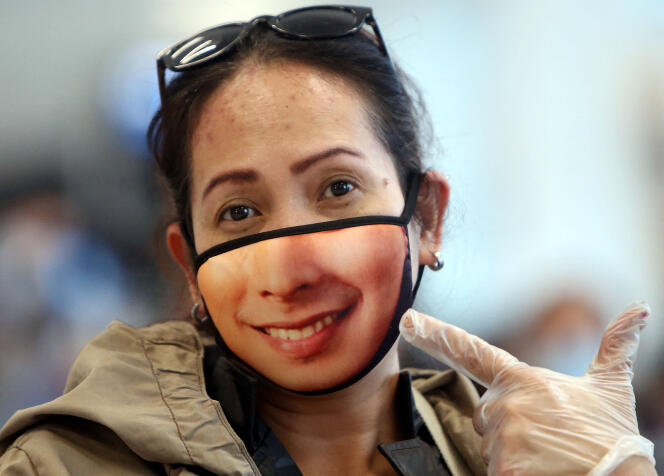 Une femme montre son masque à l’aéroport international du Koweït, le 3 avril 2020.