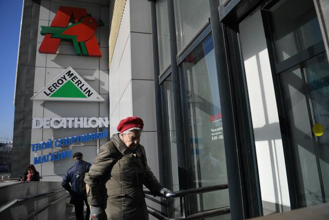 Une femme entre dans un centre commercial de Moscou, il 24 marzo 2022, dans lequel se trouvent un supermarché Auchan et des magasins Leroy-Merlin et Decathlon.