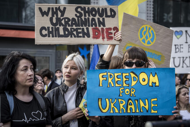 Des manifestants brandissent des affiches devant le sommet de l'UE, à Bruxelles, jeudi 24 mars 2022. L'Union européenne a préservé un sentiment d'unité rarement vu à travers quatre séries de sanctions sans précédent contre la Russie suite à son invasion de l'Ukraine, mais les 27 dirigeants ont fait face à une division sur la plus grande question de toutes : l'énergie.
