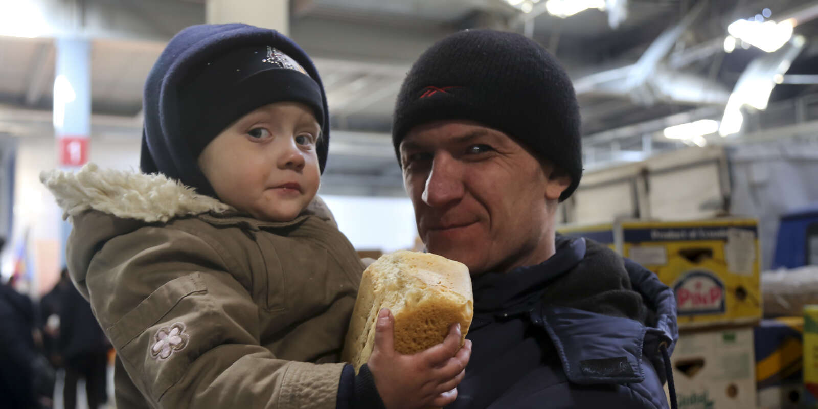 Un père et son enfant, dans un supermarché, près de Marioupol, en Ukraine, le 24 mars 2022.