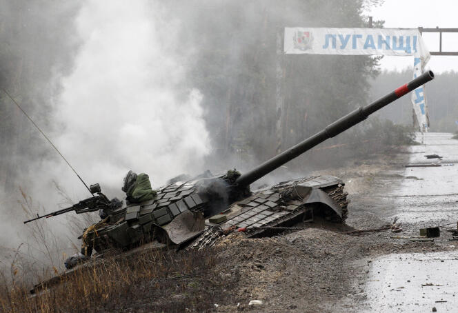 De la fumée s’élève d’un char russe détruit par les forces ukrainiennes sur le bord d’une route dans l’oblast de Louhansk, le 26 février 2022.