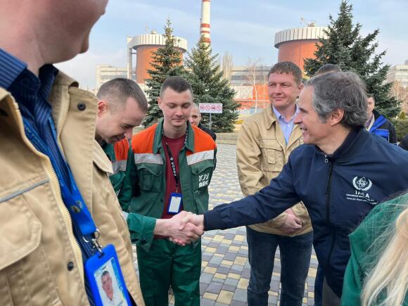 El director general del Organismo Internacional de Energía Atómica (OIEA), Rafael Grossi, saluda a un empleado de la central nuclear en el sur de Ucrania, el miércoles 30 de marzo de 2022.