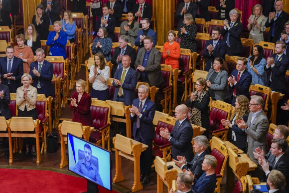 Le Premier ministre norvégien Jonas Gahr Støre, au centre, et le reste du Parlement norvégien applaudissent le Président ukrainien Volodymyr Zelenskyj après son discours devant le Parlement norvégien à Oslo, Norvège, le 30 mars 2022.