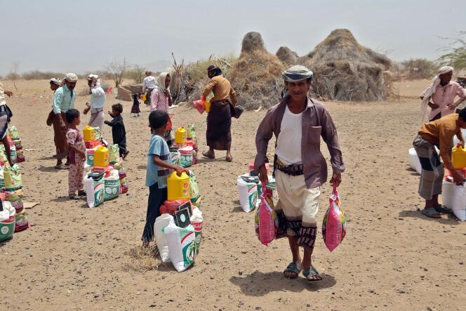 Des Yéménites, déplacés par le conflit, reçoivent une aide alimentaire et des fournitures pour répondre à leurs besoins de base, dans un camp du district de Hays, dans la province occidentale de Hodeïda ravagée par la guerre, le 29 mars 2022.