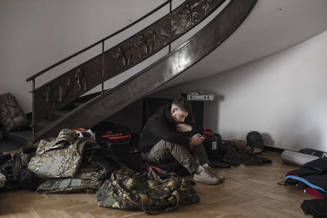 Un jeune Biélorusse entouré de matériel à destination de l’Ukraine, à Varsovie, en Pologne, le 7 mars.
