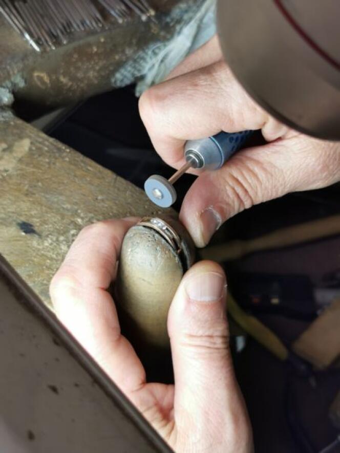 A jeweler cuts a diamond-encrusted ring to recycle the gold into a new piece of jewelry.