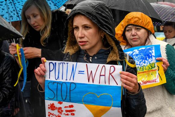Des personnes tiennent des pancartes alors qu'elles participent à une manifestation contre la guerre en Ukraine, à Podgorica, capitale du Monténégro, le 3 avril 2022.