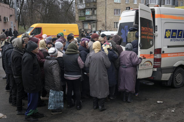 People wait for medicines after a convoy of military and humanitarian vehicles arrived on Saturday (April 2) in Boutcha, a formerly Russian-occupied suburb of Kiev, Ukraine.