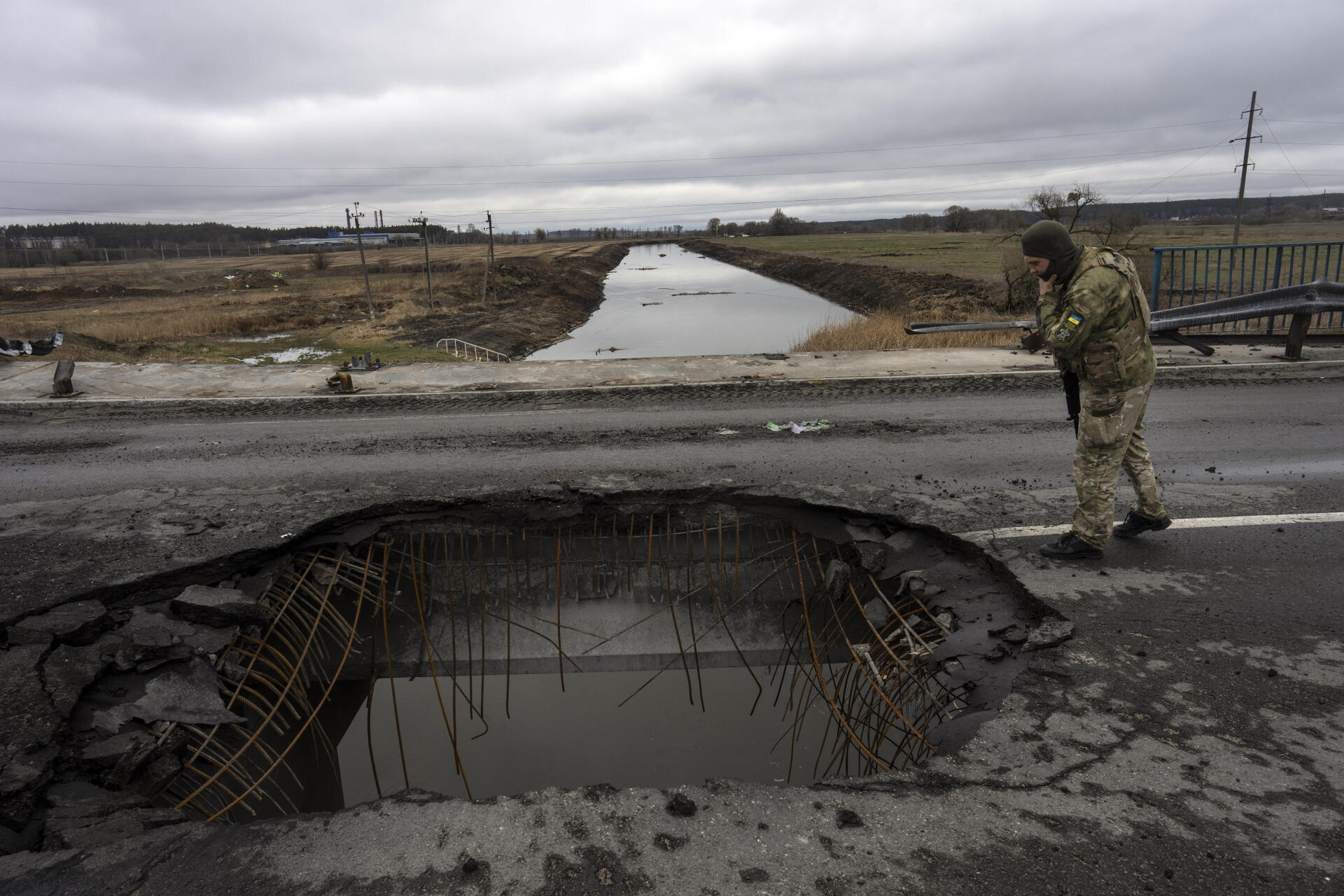 A Ukrainian soldier looks at a damaged bridge in Boutcha, on the outskirts of Kiev, on Saturday, April 2.