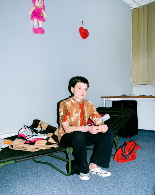 Anna Furman, 52, from Kramatorsk, photographed March 25-27, 2022, in the shelter for Ukrainian refugees at the Old Theater in Warsaw.  At his feet, his little red exile bag.