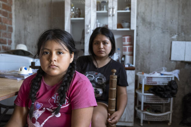 Luciana (7 ans) et Claudia (18 ans) dans le salon de leur maison, à San Juan de Lurigancho, Lima, le 15 mars 2022. Elles ont perdu leur père, Lazaro Contreras, en 2020.