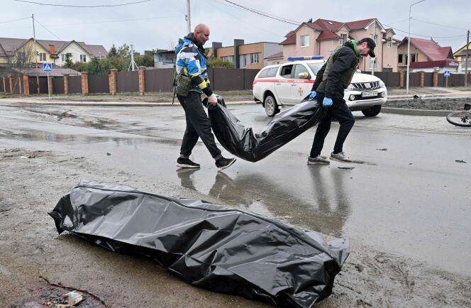 Des agents municipaux ramassent les corps retrouvés dans la ville libérée de Boutcha. Moscou dénonce une mise en scène. À Boutcha, le 3 avril 2022.