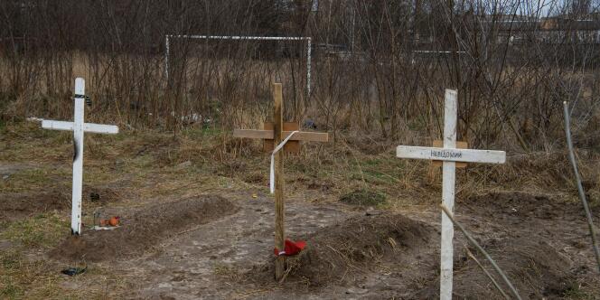 Des tombes de civils, à Boutcha, dans la région de Kiev, le 4 avril 2022. Sur une croix est inscrit « Inconnu ».