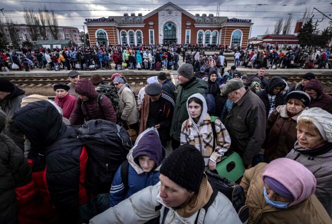 Des familles marchent sur un quai pour monter dans un train à la gare centrale de Kramatorsk, dans l’est du pays, alors qu’elles fuient la ville, le 5 avril 2022.