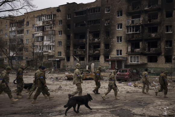 Des soldats ukrainiens passent devant des bâtiments résidentiels fortement endommagés à Irpine, à soixante kilomètres au sud-ouest de Kiev, en Ukraine, mercredi 6 avril 2022.