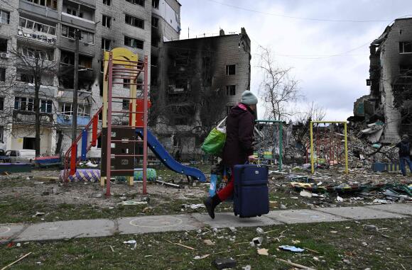 Une femme récupère des affaires parmi les débris des immeubles d’habitation à Borodianka, le 6 avril 2022.