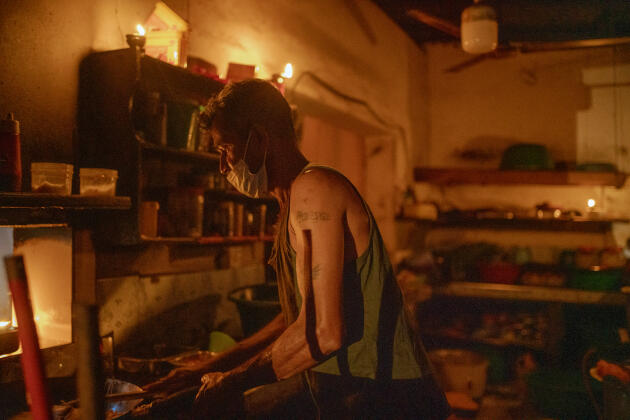 Udayantha dans la cuisine de son restaurant éclairé à la bougie, le 2 mars 2022, à Soysapura (Sri Lanka).
