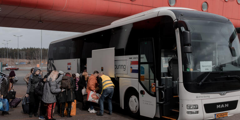 06.04.2022 PTAK Expo Centre, Warsaw, POLAND. Refugees reception centre where thousands of people fleeing from Ukraine seek for shelter. As some of them stay in the centre others decide to continue their journey further into European Union. 

Pictured bus is heading The Netherlands 

Photographs by Jedrzej Nowicki for Le Monde