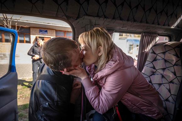 Une femme embrasse son mari alors qu'elle s'apprête à partir en bus, au lendemain d'une attaque à la roquette contre une gare de Kramatorsk, le 9 avril.