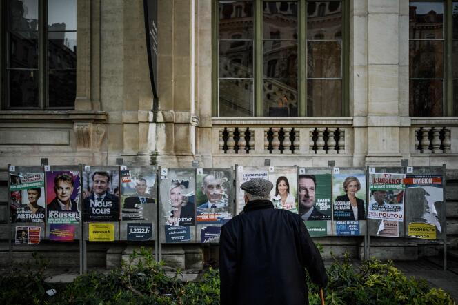 Un hombre frente a paneles electorales, en Lyon, el 10 de abril de 2022.