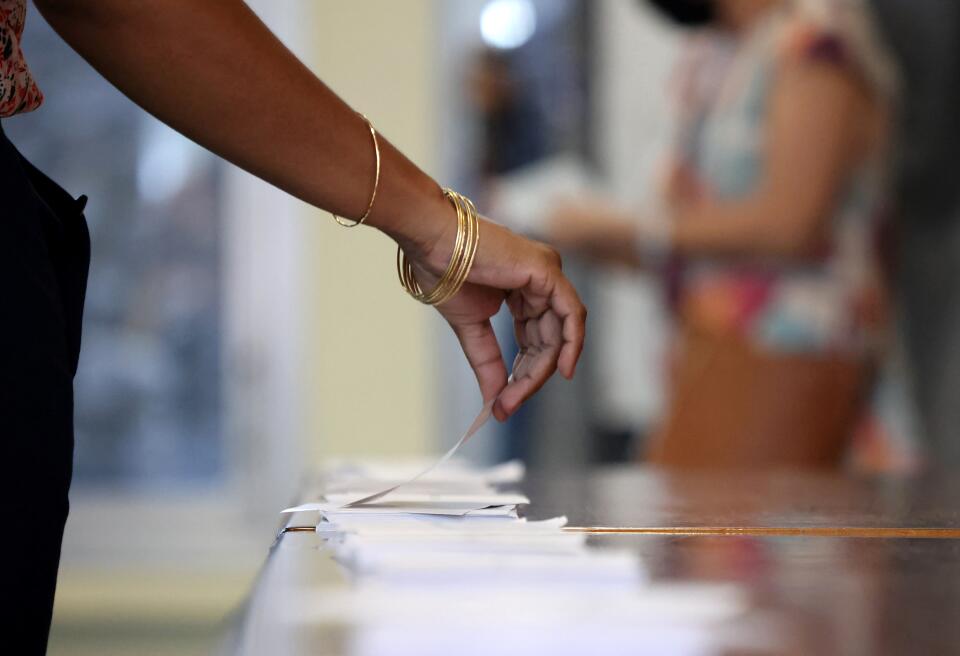 Un elettore si prepara a votare per la prima fase delle elezioni presidenziali francesi in un seggio elettorale a La Possession, sull'isola francese di Reunion, nell'Oceano Indiano, il 10 aprile 2022. - (Foto di Richard BOUHET / AFP)