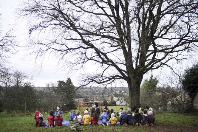 Une enseignante et ses élèves sont assis dans un champ lors d’une leçon en plein air au contact de la nature, à Clave, le 4 février 2021.