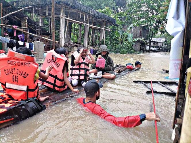 Le personnel de la garde côtière évacue les habitants de leurs maisons inondées dans la ville de Panitan, province de Capiz, le 12 avril 2022.