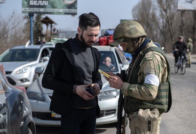 Un soldat russe de la garde nationale contrôle des véhicules à l’entrée de Melitopol, en Ukraine, le 25 mars 2022, photo fournie par une agence d’Etat russe.