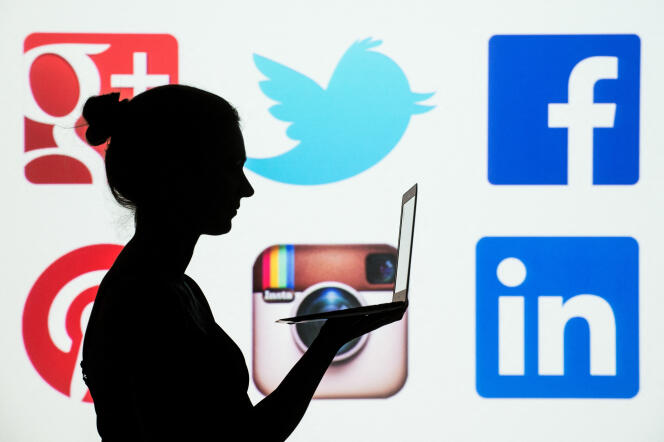 A silhouette of a woman holding a laptop in front of the logos of the social networks Google Plus, Twitter, Facebook, Pinterest, Instagram and LinkedIn.