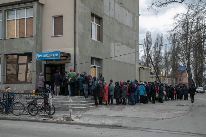 Residents wait outside a food aid distribution point in Chernihiv, Ukraine, April 12, 2022.