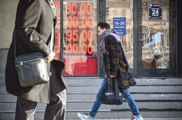 People walk past a currency exchange office in central Moscow on February 28, 2022, with zeros on the scoreboard since there are no three-digit sections on it to display the current exchange rate. - The Russian ruble collapsed against the dollar and the euro on the Moscow Stock Exchange on February 28 as the West punished Moscow with harsh new sanctions over the Kremlin's invasion of Ukraine. The ruble fell sharply at the start of currency trading, reaching 100.96 to the dollar, compared to 83.5 on Wednesday, the day before the invasion of Ukraine, and 113.52 to the euro, compared to 93.5 before the assault. (Photo by Alexander NEMENOV / AFP)