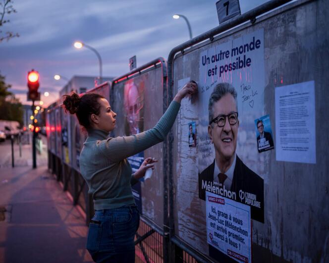Une militante du parti des « insoumis » écrit des mots de remerciements sur les affiches du premier tour de l’élection présidentielle de Jean-Luc Mélenchon, à Asnières, et remercie les électeurs d avoir voté pour lui. 