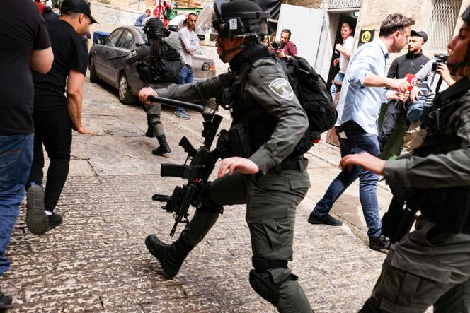 Members of the Israel Border Police chase Palestinian youths in the Old City of Jerusalem, Sunday, April 17, 2022.