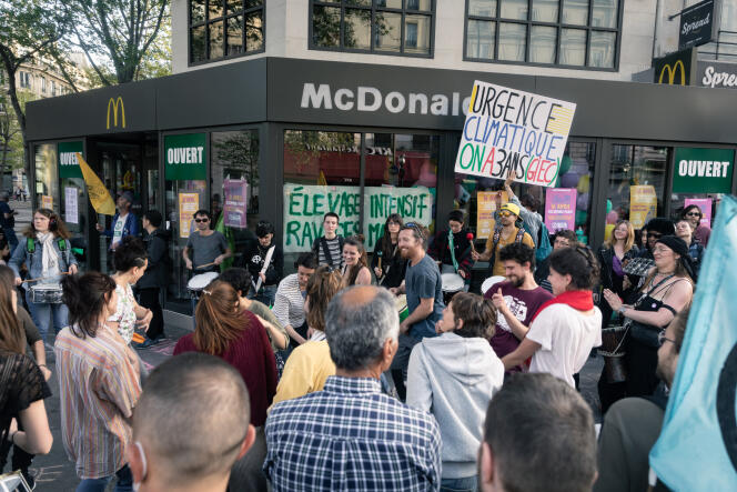 Gli attivisti di Extinction Rebellion bloccano l'ingresso di McDonald's all'angolo tra i boulevard Saint-Denis e Sébastopol a Parigi, 17 aprile 2022.  