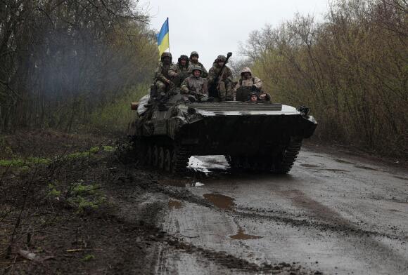 Des soldats ukrainiens à bord d’un véhicule blindé de transport de troupes (APC), non loin de la ligne de front avec les troupes russes, dans le district d’Izioum, région de Kharkiv, le 18 avril 2022, pendant l’invasion russe de l’Ukraine.