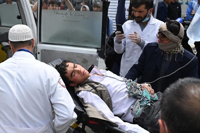 Medical staff move a wounded youth on a stretcher outside a hospital after three blasts rocked a boys' school in a Shiite Hazara neighbourhood in Kabul on April 19, 2022.