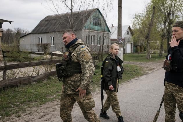 Une équipe de membres de la défense territoriale, tous volontaires, dans les rues désertées de Sviatohirsk. Au premier plan, Vladimir, commandant de 43 ans.